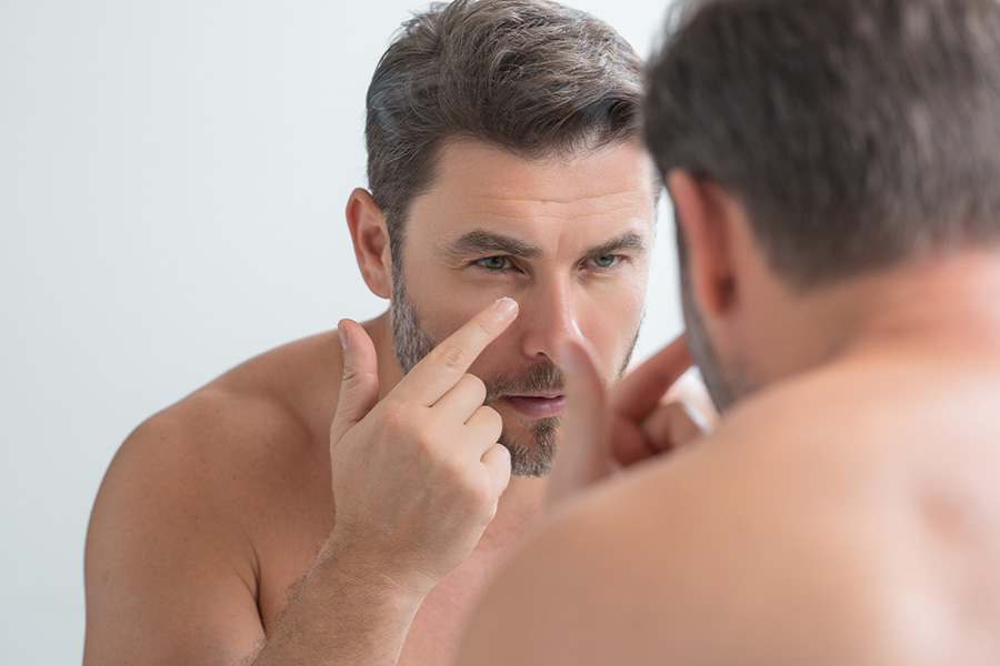 Man applying an Anti-Aging skin treatment to look younger during a consultation for facial and body scans, weight management, low testosterone treatment, and other men's health services at Men's Only Medical in West Palm Beach and Palm Beach.