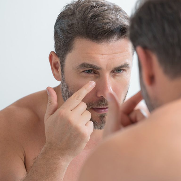 Man applying an Anti-Aging skin treatment to look younger during a consultation for facial and body scans, weight management, low testosterone treatment, and other men's health services at Men's Only Medical in West Palm Beach and Palm Beach.